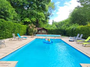 una piscina con una balsa en el medio en Le Moulin Etourneau - 3 gîtes avec 2 piscines, en Champagnac