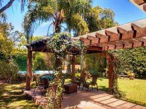 a wooden pergola with a table and chairs in a yard at Casa ampla no Laranjal in Pelotas