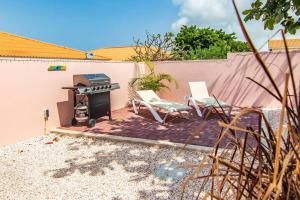 a patio with two chairs and a grill at Appartement midden op het eiland: Pension-Nada in Willemstad