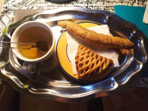 a tray with a plate of food with waffles and a cup of coffee at Cuki Apartment in Budapest