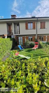 une maison avec deux chaises de jardin et un frisbee dans l'établissement Villetta Camelia, à Guamo