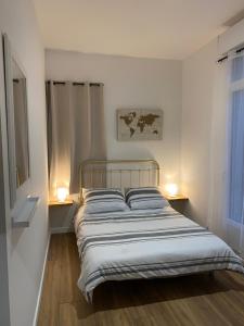 a bedroom with a bed with two lamps on the floor at Dépendance privée à la campagne in Saint-Cirice