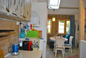 a kitchen with a refrigerator and a table with chairs at Apartment Mediterraneo Blue Sky in Perast