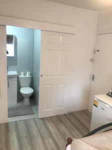 ロンドンにあるEn Suite Double Roomのバスルーム(トイレ、白いドア付)