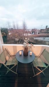 a table with two chairs and a vase with flowers on a balcony at Balcon du Champ de Mars - Wifi / Parking in Angoulême