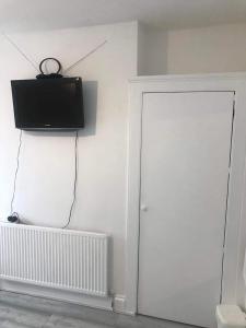 Habitación con puerta y TV en la pared en En Suite Double Room en Londres