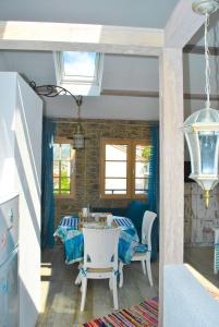 ein Esszimmer mit einem Tisch, Stühlen und Fenstern in der Unterkunft Apartment Mediterraneo Blue Sky in Perast