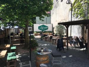 a patio with tables and chairs and a building at Domhotel in Sankt Wendel