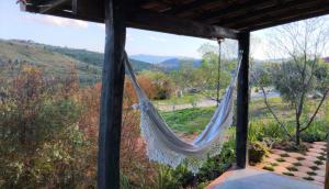 - un hamac sur une terrasse couverte avec vue sur les montagnes dans l'établissement Pousada Serra da Paz, à Carrancas