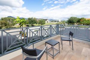 a balcony with two chairs and a view of the water at Courtyard by Marriott Port of Spain in Port-of-Spain