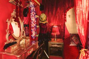 Cette chambre rouge comprend des rideaux rouges et un miroir. dans l'établissement Hotel Pelirocco, à Brighton et Hove