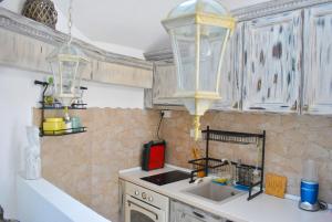 a kitchen with a sink and two chandeliers at Apartment Mediterraneo Blue Sky in Perast
