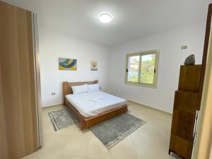 um quarto com uma cama e uma janela em Villa Gaia em Vlorë