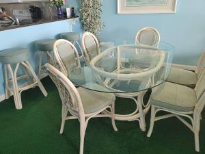 une table en verre entourée de quatre chaises dans l'établissement Windy Hill Dunes 105 condo, à Myrtle Beach