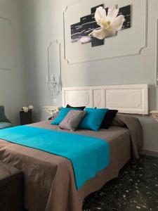 a bedroom with a large bed with a blue blanket at Casa Dalfea in Mazara del Vallo