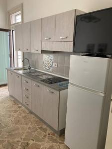 a kitchen with a white refrigerator and a stove at Casa Dalfea in Mazara del Vallo