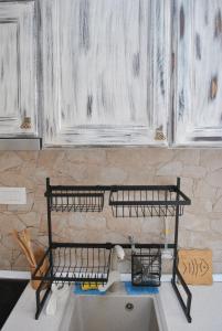 a kitchen sink with a metal shelf above it at Apartment Mediterraneo Blue Sky in Perast