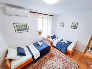 2 Betten in einem Zimmer mit einem Teppich in der Unterkunft Apartments Villa Rosa in Split