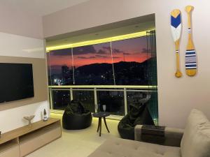 un soggiorno con una grande finestra con vista di Book Santos - Unlimited 2112 - Moderno e Elegante a Santos