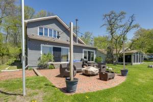 a home with a patio and a house at Spacious Delton Home with Fire Pit and Lake Views in Delton