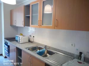 a kitchen with a sink and a microwave at Airport 5 minutes by car - 24h check in in Santa Cruz