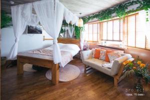 a bedroom with a canopy bed and a couch at Hotel Pelirocco in Brighton & Hove