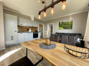 eine Küche und ein Esszimmer mit einem Holztisch in der Unterkunft Ferienwohnung Bonny in Sankt Andreasberg