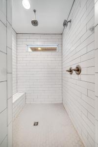 a bathroom with a shower with white tiles at Nell's Haven Two Miles To Downtown & Broadway in Nashville