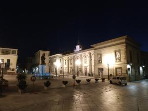 Bed and Breakfast In Piazza Orazio في فينوسا: مبنى كبير في الليل مع أضواء