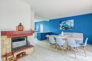 a living room with a fireplace and a table and chairs at Maison de vacances Bisca in Biscarrosse
