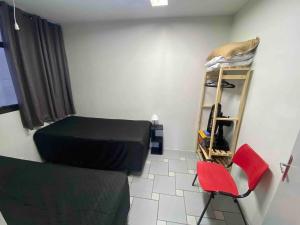 Cette petite chambre comprend un lit et une chaise. dans l'établissement Apart 2 dorm. Prox Cambuí Wi-Fi Gar Var Note Pet, à Campinas