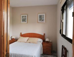 1 dormitorio con 1 cama y 2 cuadros en la pared en Casa Juncal, en Tarifa