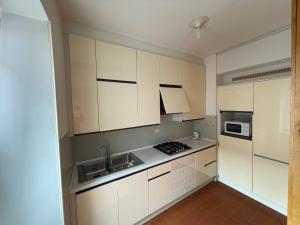 a kitchen with white cabinets and a stove at Torboletta Apartments in Nago-Torbole