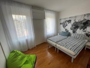 Una pequeña habitación con una cama y una ventana. en Torboletta Apartments, en Nago-Torbole