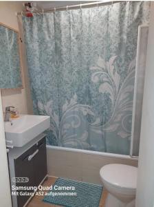 a bathroom with a shower curtain and a toilet at Apartment mit 3 Zimmer in Wolfratshausen