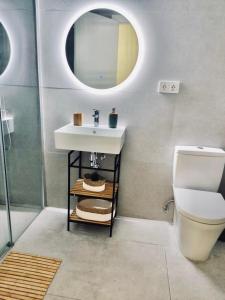 W łazience znajduje się umywalka, toaleta i lustro. w obiekcie PARAISOS DE AGAETE w mieście Puerto de las Nieves