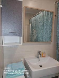 een badkamer met een wastafel en een spiegel bij Apartment mit 3 Zimmer in Wolfratshausen