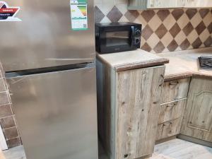 a kitchen with a stainless steel refrigerator and a microwave at شقة لين طيبة للعوائل Leen Taibah Ap. for family's in Al Madinah
