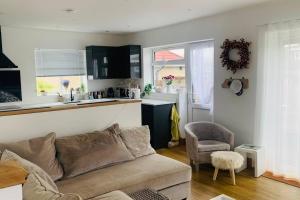 a living room with a couch and a kitchen at Love Lancing by the Sea with private Hot Tub sleeps 8 & plentiful free parking in Lancing