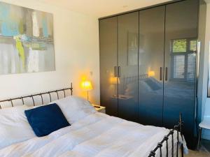 een slaapkamer met een bed met een blauw kussen erop bij Love Lancing by the Sea with private Hot Tub sleeps 8 & plentiful free parking in Lancing