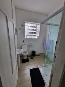 a bathroom with a toilet and a glass shower at Oh! Madalena Hostel in Sao Paulo