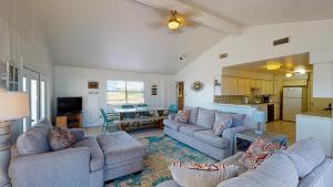 sala de estar con 2 sofás y cocina en LP10 Beach House on Stilts, Ocean View from Back Porch, Boardwalk, Outdoor Shower, en Port Aransas