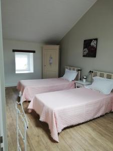 dwa łóżka siedzące obok siebie w sypialni w obiekcie LA MAISON D'ALIDA w mieście Nueil-sous-Faye