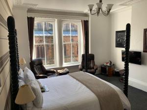 a bedroom with a bed and two chairs and a window at The Middleham in Whitby