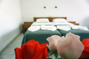 two beds in a room with two roses at Aphrodite Studios & Apartment in Bali