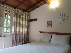 a bedroom with a bed and a window at Pitanga Ilha Grande in Abraão