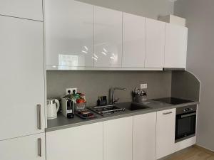 a white kitchen with white cabinets and a sink at Camelia luxury apartment in Karistos