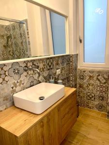 baño con lavabo blanco y ventana en La casa di Toto en Nápoles