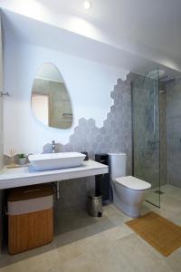 W łazience znajduje się umywalka, toaleta i lustro. w obiekcie Tsakmakis Villas Luxury- Panoramic Sea View - Lefkada w mieście Tsoukalades