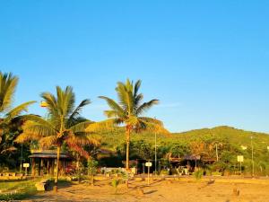 a resort with palm trees and a mountain in the background at Casita Madame - Frente al Mar con Desayuno Gourmet in Puerto López +25 photos